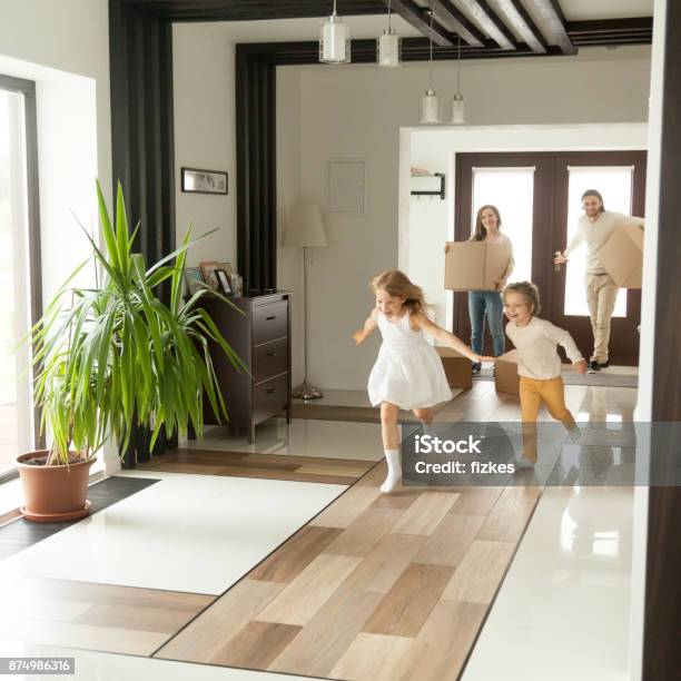 Verspielte Kinder Laufen In Neues Haus Familie Bewegt Sich In Konzept Stockfoto und mehr Bilder von Eigenheim