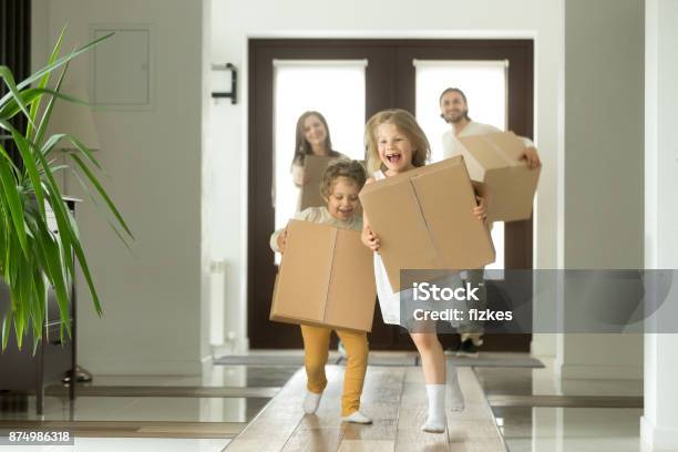 Begeistert Kinder Laufen Holdingboxen Familie Umzug In Neues Haus Stockfoto und mehr Bilder von Eigenheim