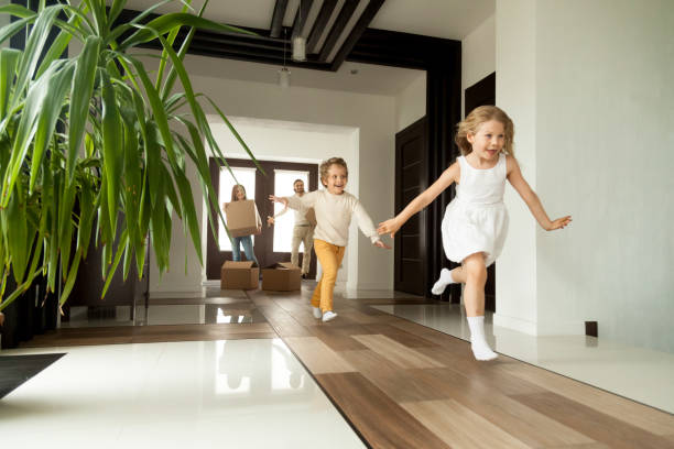 enfants excités courir dans la maison, le jour du déménagement dans la nouvelle maison - indoor court photos et images de collection