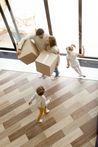 istock Family with boxes moving in new home, vertical top view 874986474