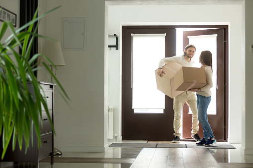 Par llevar cajas entrando en casa, los propietarios de viviendas en nueva casa photo