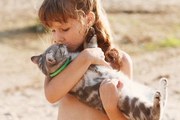 istock Happy child with cat outdoors. 874988156