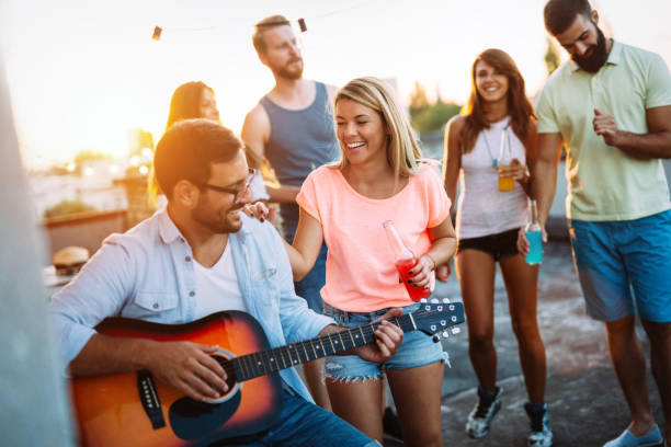 istock Group of happy friends having party on rooftop 874991130