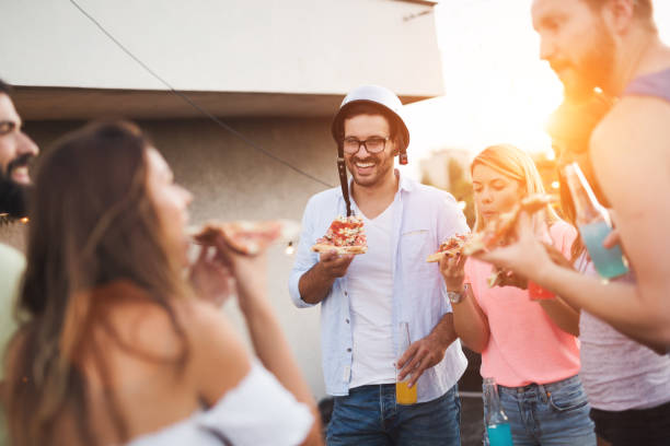 istock Group of happy friends having party on rooftop 874991482