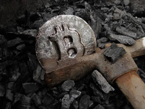 Photo of Bitcoin mining. A mine with real hardware. Symbols of block chain technology for crypto currency  metal coin, coal, pickaxe