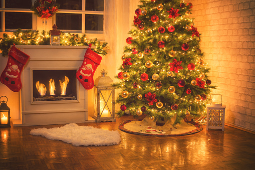 Christmas tree near fireplace in decorated living room