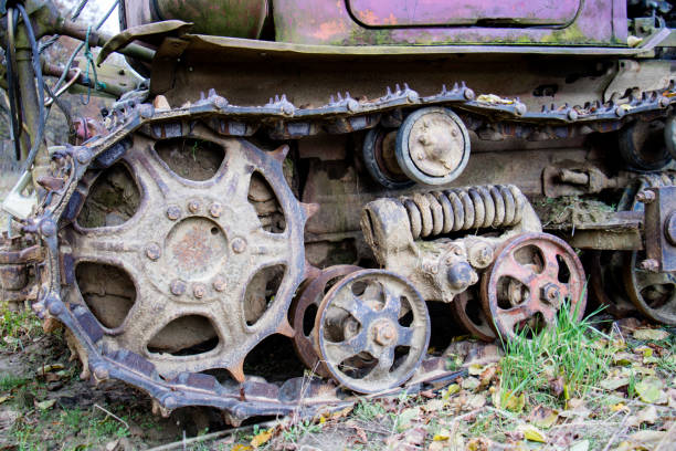 Old crawler bulldozer. A metal caterpillar muddy and contaminated with soil during field work. Autumn season