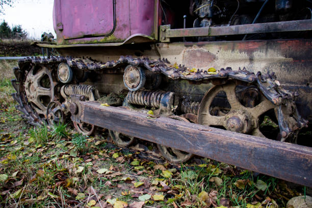 Old crawler bulldozer. A metal caterpillar muddy and contaminated with soil during field work. Autumn season