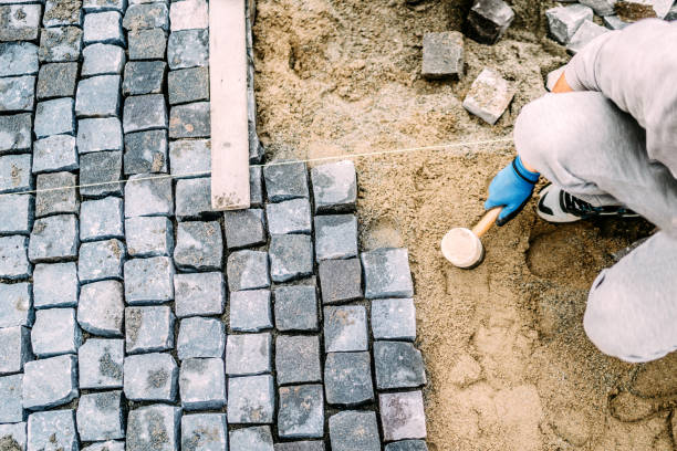 istock Manual labor, industrial worker laying stone pavement on sand path 875003976