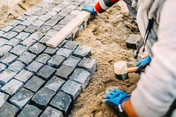 istock Industrial details of construction site - worker laying granite stones as walking path 875003980