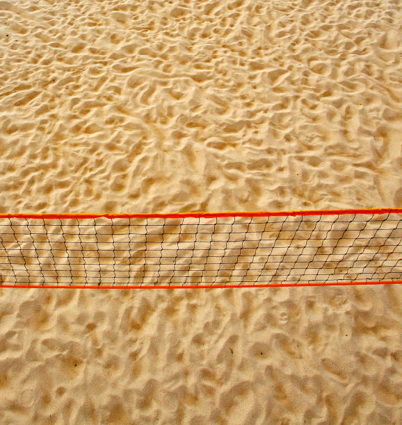Pole aerial image of a beach volleyball court. Includes an overhead perspective of the net and sand texture.
