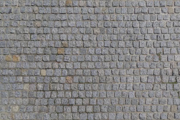 el camino está pavimentado con piedras de granito de forma cuadrada como un fondo o telón de fondo - granite block stone cobblestone fotografías e imágenes de stock