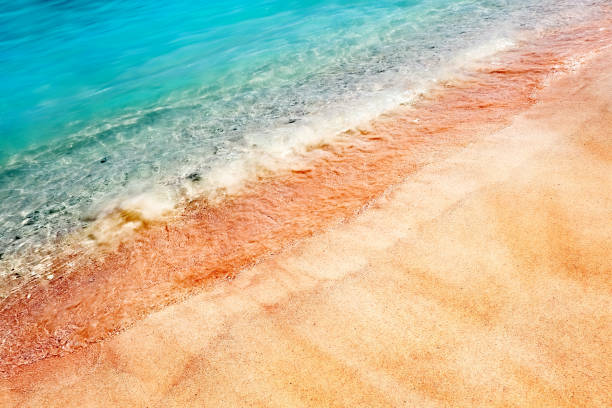 istock Multicolored pink sand and blue water on a deserted red beach. Tropical sand background. 875007670
