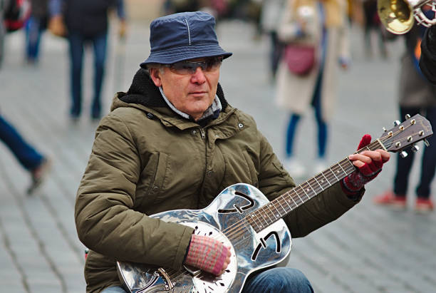 мусикант играет на гитаре на старо-городской площади - musikant стоковые фото и изображения