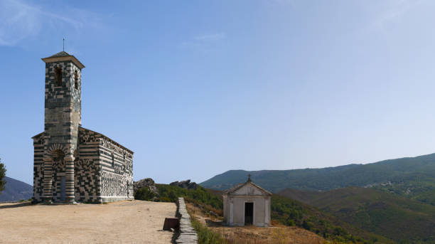 corsica: view of the church of san michele de murato, a small chapel built in the 12th century in polychrome stones and typical pisan romanesque style - black blue escape multi colored imagens e fotografias de stock