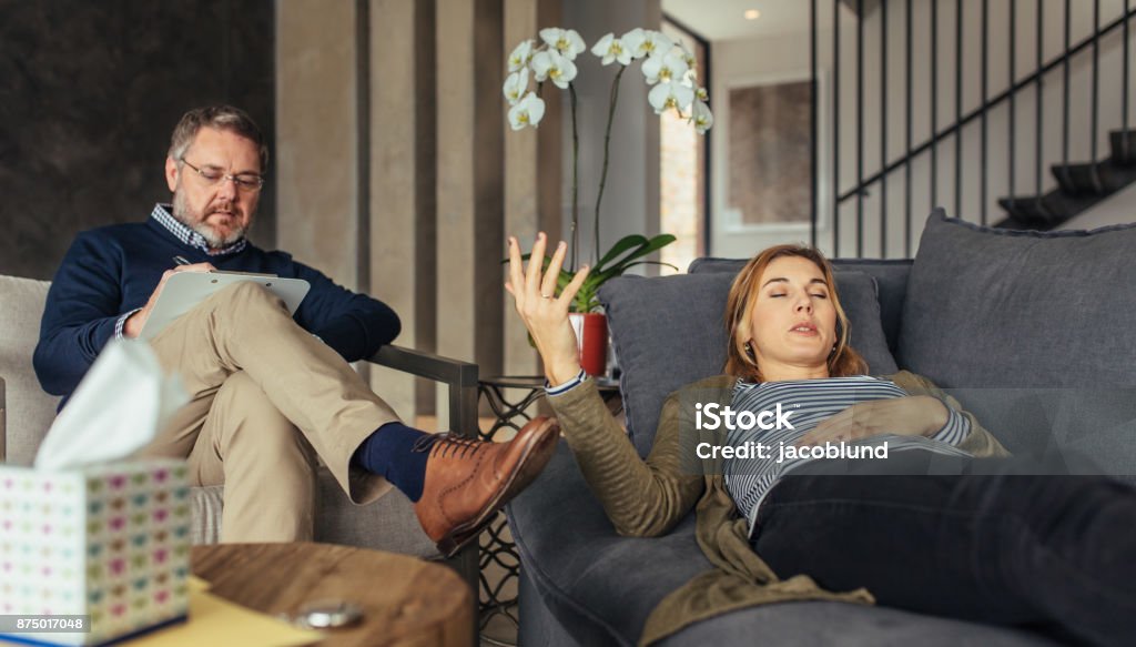 Paciente femenino de discutir sus problemas con psicoterapeuta - Foto de stock de Acostado libre de derechos