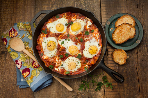 Overhead view of shakshouka on a rustic background.