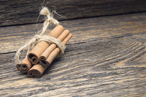 Cinnamon sticks wrapped with rope on wooden rustic table