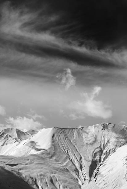istock Black and white view on off-piste snow slope and sky with clouds 875025410