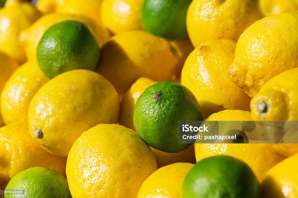 Fresh lime anf lemons on sale Fresh lime and lemons sale on farm's market at sunny day, selective focus Lemon - Fruit Stock Photo