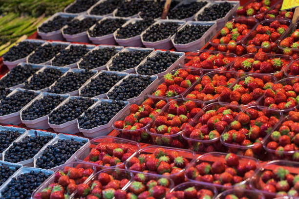 A lot of strawberry and blueberry in box on sale at farms market, selective focus