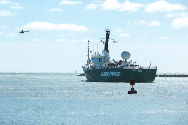 The Icebreaking Arctic Sunrise Leaving Miami The Arctic Sunrise, Greenpeace’s icebreaking research ship, leaving land after been docked in Downtown Miami for several days. The helicopter of the organization itself flies over the ship. greenpeace activists stock pictures, royalty-free photos & images