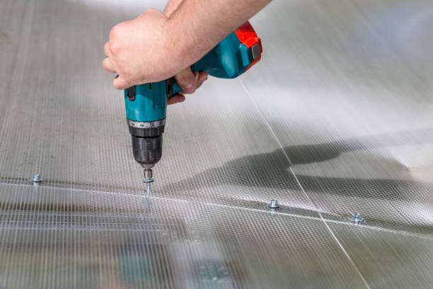 Worker screwing screw into polycarbonate stock photo