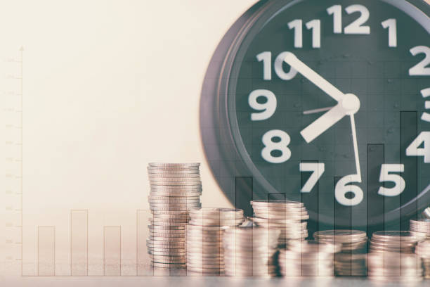 istock Double exposure of alarm clock and step of coins stacks on working table with financial graph chart, time for savings money concept. 875054074