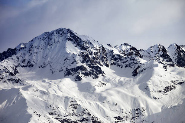 istock Snow sunlight mountain and gray sky in evening 875061728
