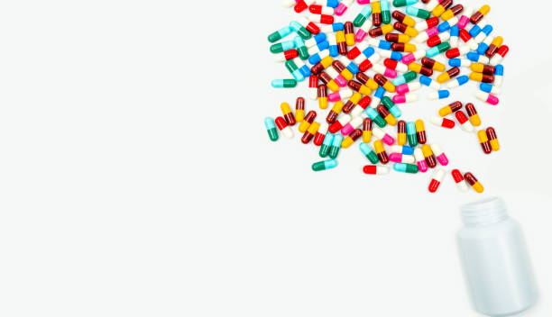 istock Pouring antibiotics capsule pills into plastic bottle isolated on white background with copy space. Drug resistance concept. Antibiotics drug use with reasonable and global healthcare concept. 875070834