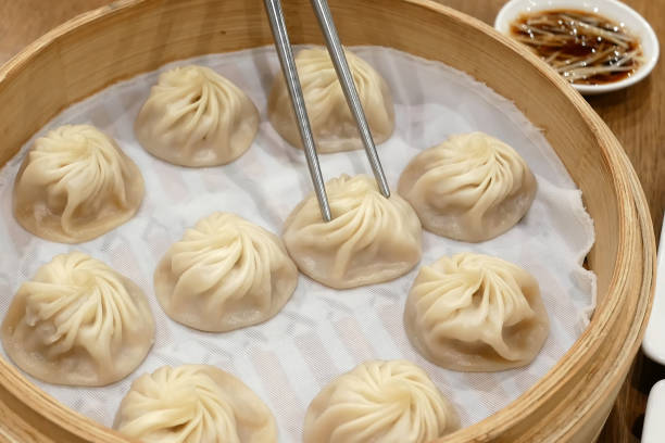 istock People eating soup dumpling buns with chopsticks in restaurant 875074888