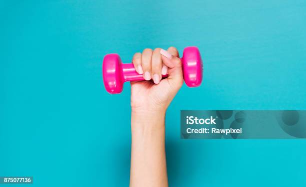 Closeup Of Hand Holding Pink Dumbbell Stock Photo - Download Image Now - Dumbbell, Blue Background, Close-up