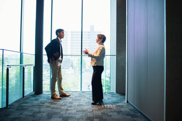 istock Two business people talking in office 875084582