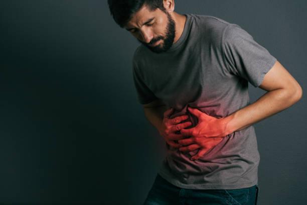 istock Young man suffering from stomach ache standing 875090740