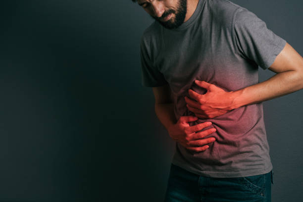 istock Young man suffering from stomach ache standing 875090886