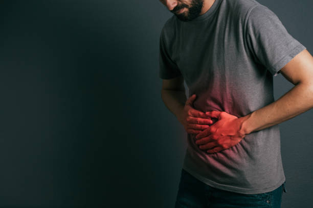 Young man suffering from stomach ache standing