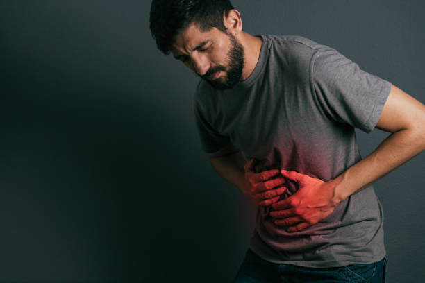 istock Young man suffering from stomach ache standing 875091190