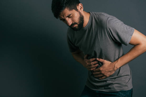 istock Young man suffering from stomach ache standing 875091196