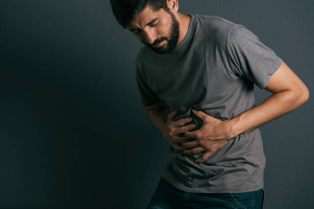 istock Young man suffering from stomach ache standing 875091236