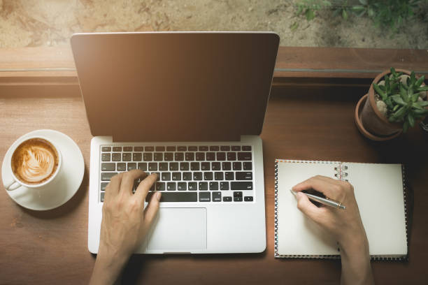 istock Business man using laptop computer with hand holding pen point n 875093380