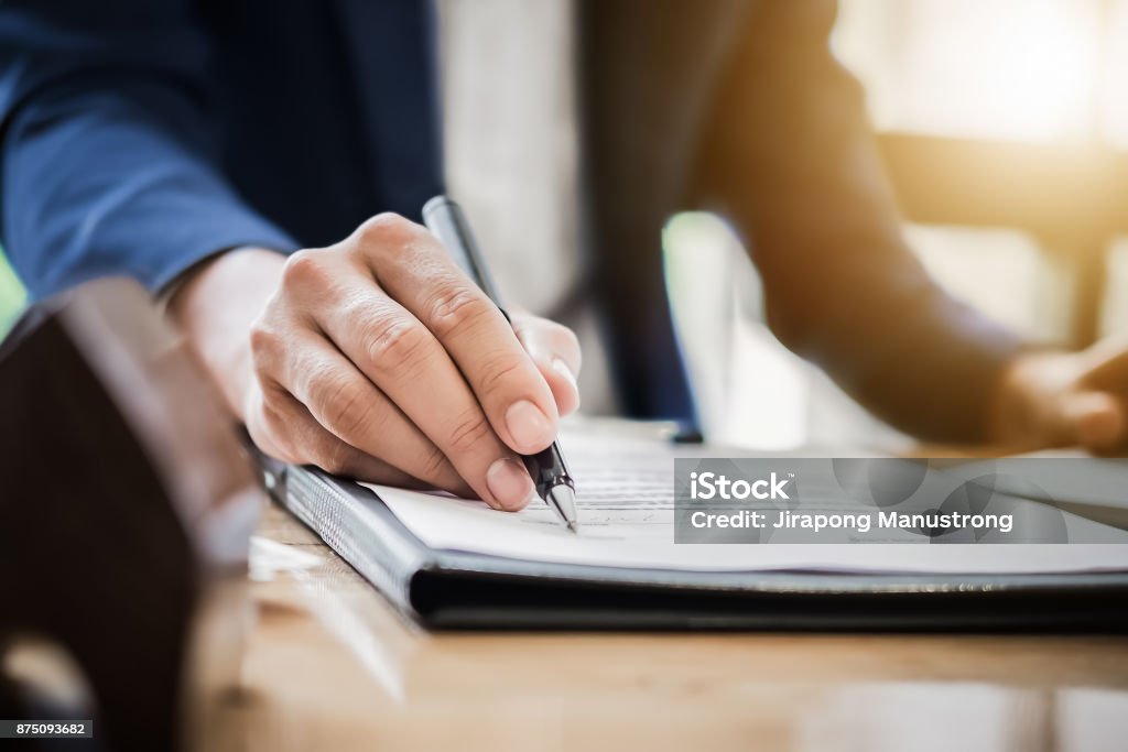 estate agent gives pen and documents agreement with customer to estate agent gives pen and documents agreement with customer to sign contract. Concept agreement Law Stock Photo