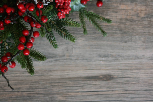 istock Beautiful Holiday Pine Tree Branches and Berries in Corner Over Wood 875094088
