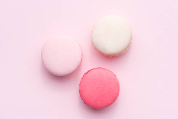 istock Tasty pink cake macaron or macaroon on pink background from above 875096868