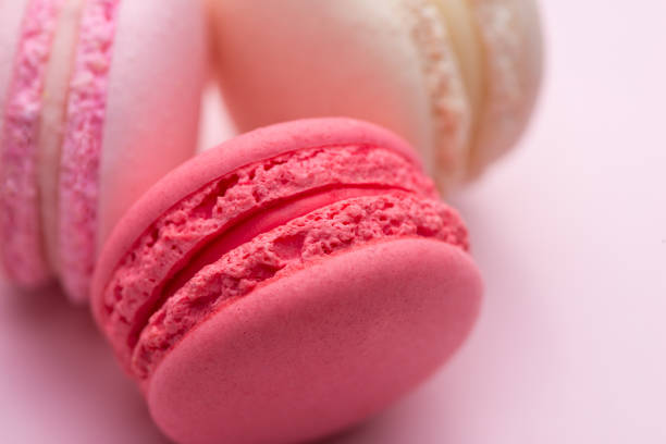 istock Tasty pink cake macaron or macaroon on pink background. Closeup. 875096918