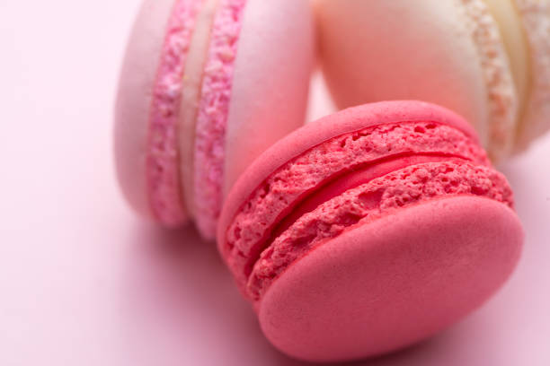 istock Tasty pink cake macaron or macaroon on pink background. Closeup. 875096926