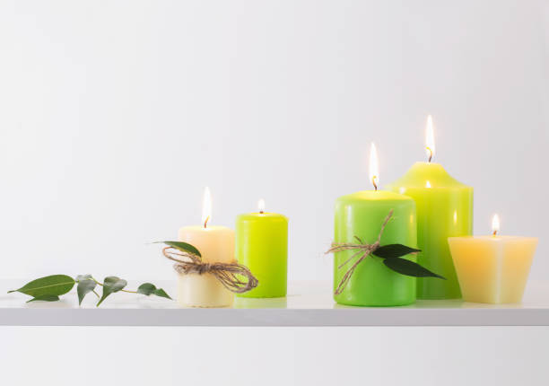istock green burning candles on a white background 875097466