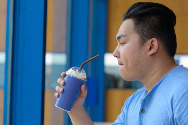 istock Young handsome Asian man relaxing at the coffee shop 875097498