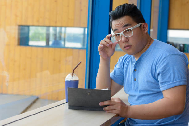 istock Young handsome Asian man relaxing at the coffee shop 875098046