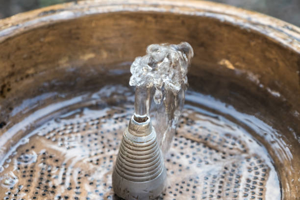 istock Close up water drops flowing from fountain 875100264