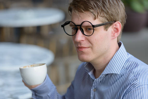 Portrait of young handsome businessman relaxing at the coffee shop around the city of Bangkok Thailand